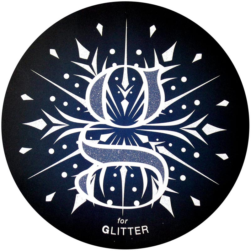 A glitter finish with a lowercase "g" and a intricate snowflake design behind the G.