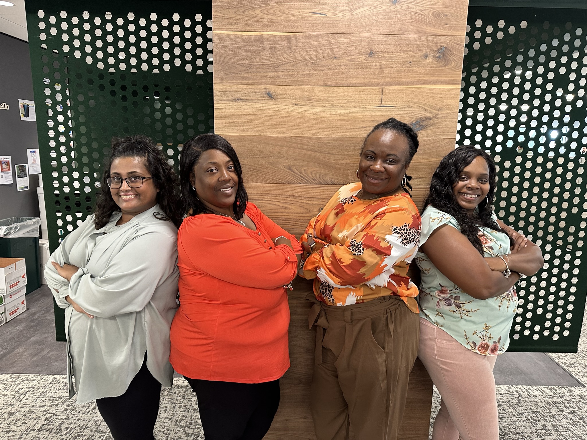 2 Pairs of women standing back to back in office setting