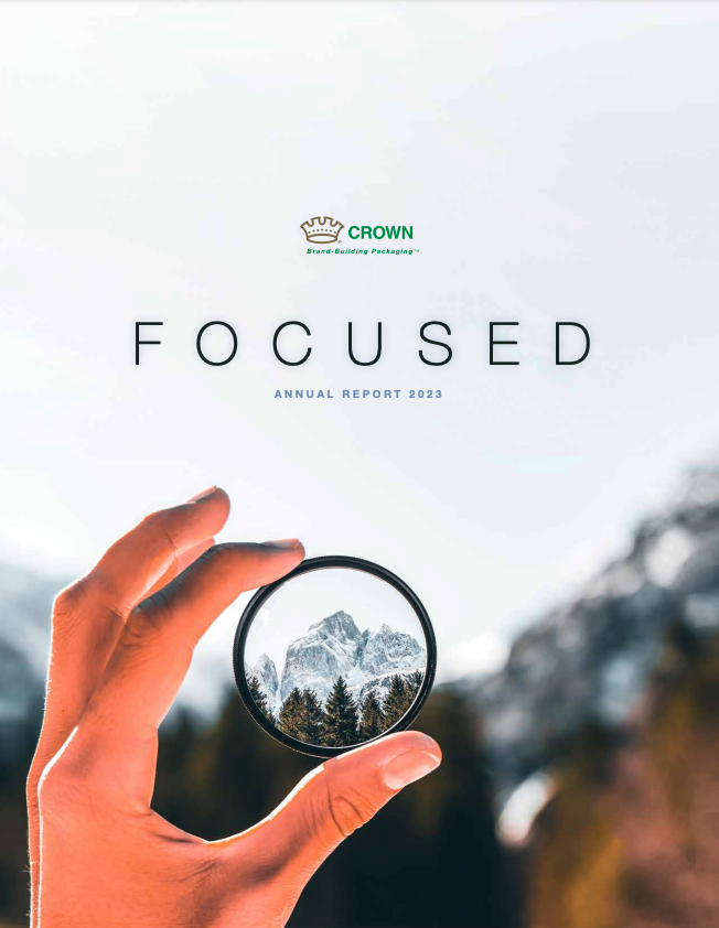Hand holding circle object that puts in focus the background of a snowy mountain scape