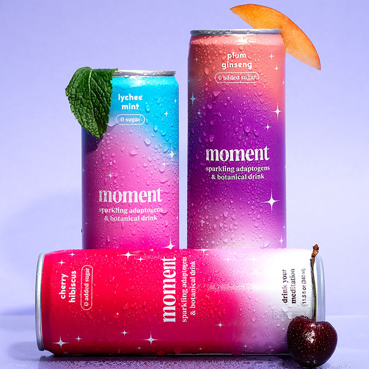 A marketing photo of three "Moment" branded aluminum cans.