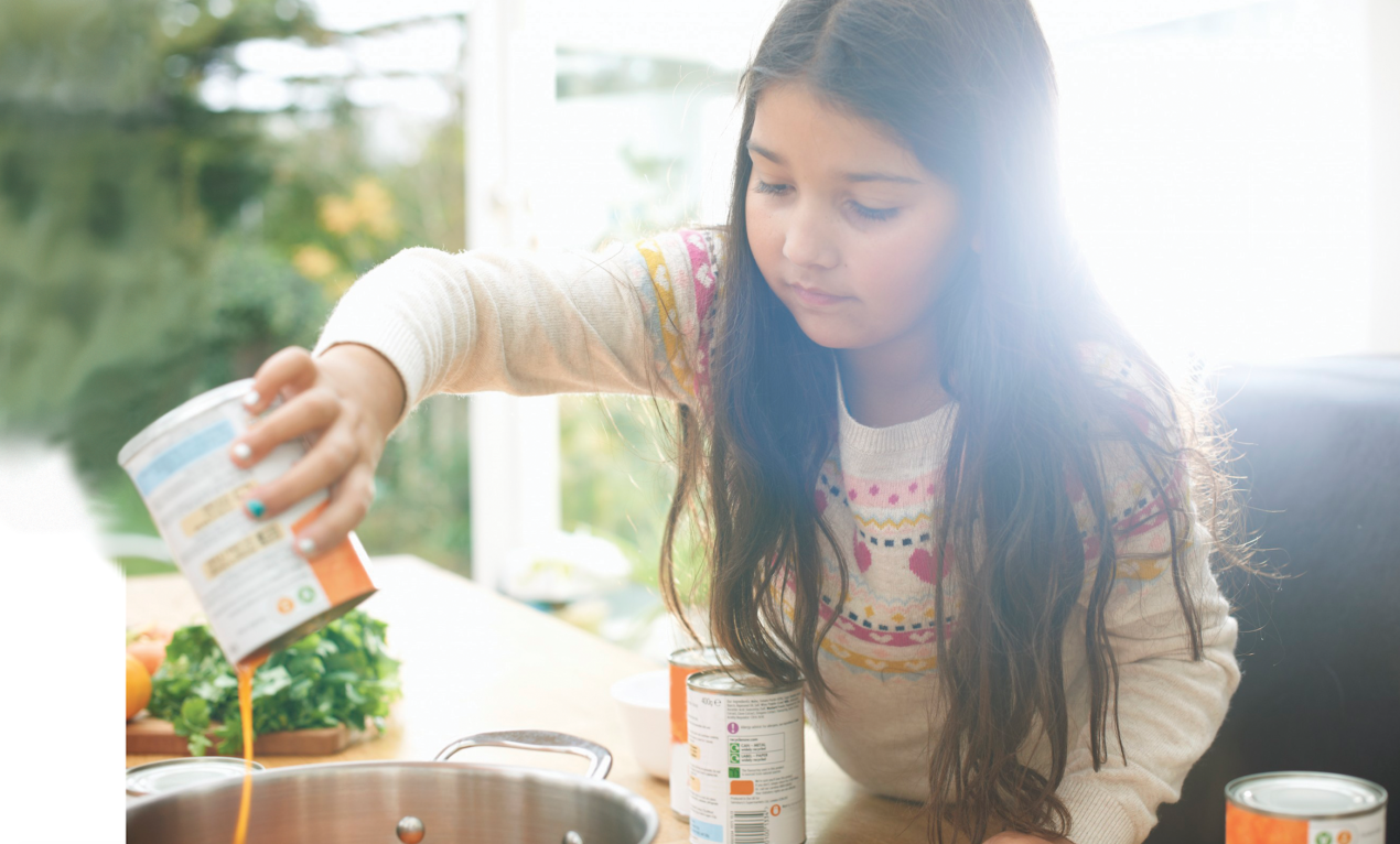 image of girl pouring can contents into a stockpot