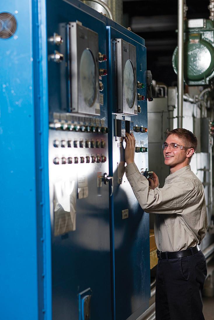 Image of Crown intern standing next to a machine