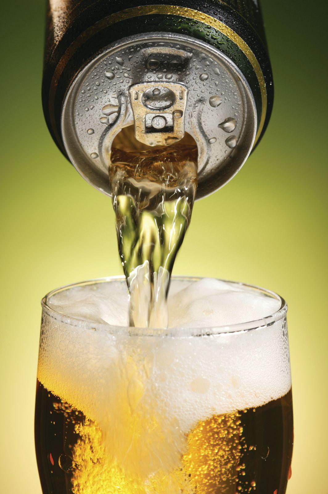 can of beer being poured into a glass