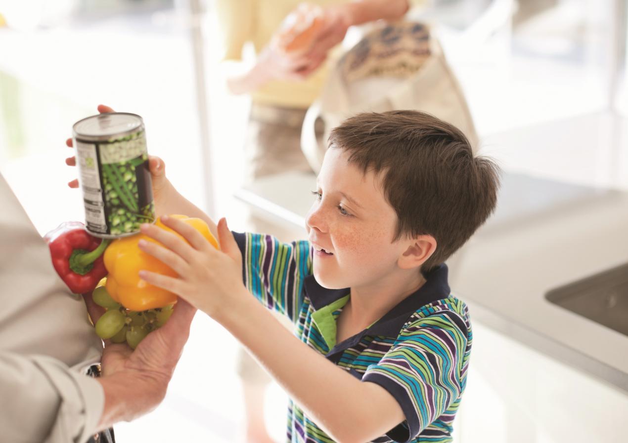 Child in Kitchen with cans