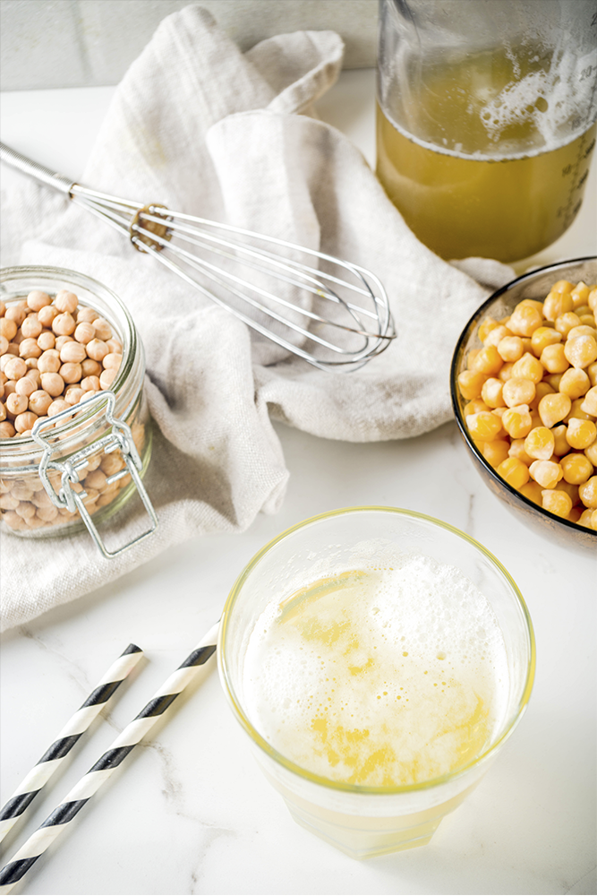 Garbanzo beans in clear containers on a while table cloth 