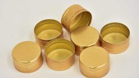 A pile of gold aluminum caps for bottles